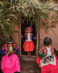 eine Gruppe von drei Frauen, die in einem Hauseingang sitzen in der Unterkunft Titilaka by Andean in Tililaca + 60 Fotos