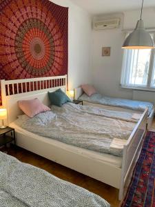 a bedroom with two beds and a large rug at Stadium Rooms in Budapest