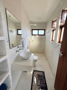 ein Badezimmer mit Waschbecken, Toilette und Spiegel in der Unterkunft Casa do Sol in São Miguel do Gostoso