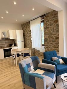 a living room with two blue chairs and a table at Ca' dei lecci in Tuoro sul Trasimeno