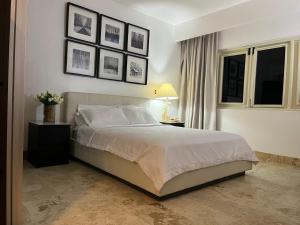 Un dormitorio con una cama y cuadros en la pared. en Antiguo Dominican Bay, en Cuevas 20 fotos más