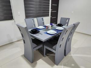 a dining room table and chairs with plates and bowls on it at Downtown Durango, Ground Floor, Spacious and Comfortable Apartment in Durango