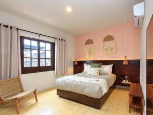 Un dormitorio con una cama y una silla y una ventana. en Hotel Libertad 1416, en Guadalajara