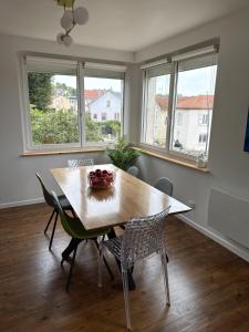 a dining room with a table and chairs and windows at Le Trente 9 in Neufchâteau