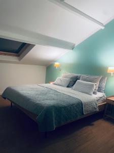 a bedroom with a large bed with a blue wall at Het Wolvennest in Maasmechelen