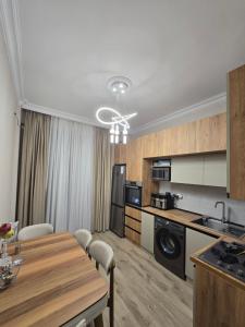 a kitchen and living room with a table and a dining room at Sumqayıt, Mərkəzdə mənzil in Sumqayyt