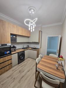 a kitchen and dining room with a wooden table and chairs at Sumqayıt, Mərkəzdə mənzil in Sumqayyt