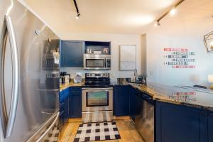 a kitchen with blue cabinets and a stainless steel refrigerator at Silvermill Lodge 8285 in Keystone