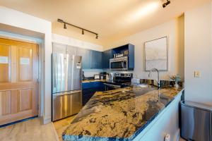 a kitchen with blue cabinets and a stainless steel refrigerator at Silvermill Lodge 8285 in Keystone