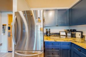 a kitchen with blue cabinets and a stainless steel refrigerator at Silvermill Lodge 8285 in Keystone +78 photos