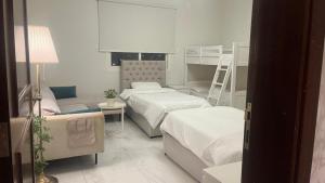 a bedroom with two beds and a couch at شاليه La veranda in Durat  Alarous