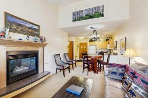 ein Wohnzimmer mit Kamin, Tisch und Stühlen in der Unterkunft Silvermill Lodge 8295 in Snake River Health Services Incorporated Heliport