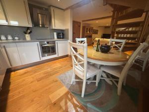 a kitchen with a table and chairs in a room at Welsh Apple Barn in Chepstow +7 photos