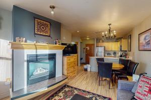 a living room with a fireplace and a kitchen at Silvermill Lodge 8202 in Keystone