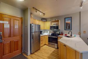 a kitchen with wooden cabinets and a stainless steel refrigerator at Silvermill Lodge 8202 in Keystone +60 photos