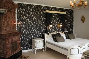a bedroom with a bed with a black and white wallpaper at Älgbergets Bed & Breakfast in Ucklum