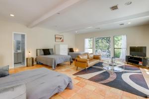 a living room with two beds and a tv at Private Pool Spacious and Secluded Magnolia Cottage in Tomball