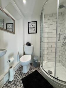 a white bathroom with a toilet and a shower at The Whitley Maisonette, Luxury Family Holiday Home in Whitley Bay +36 photos