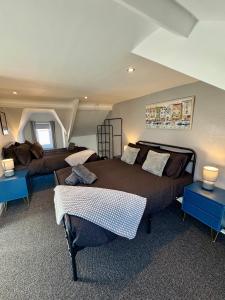 a bedroom with two beds and two blue tables at The Whitley Maisonette, Luxury Family Holiday Home in Whitley Bay