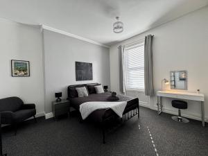 a bedroom with a bed and a chair in it at The Whitley Maisonette, Luxury Family Holiday Home in Whitley Bay