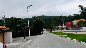 a street with a car parked on the side of a road at Chalé em Ilhabela 02 in Ilhabela