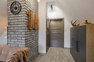sala de estar con pared de ladrillo y reloj en Rozeta, en Jurgów