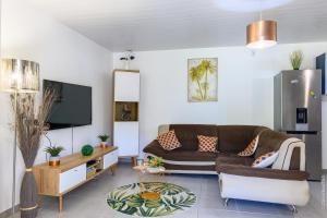 un salon avec un canapé et une télévision dans l'établissement Kayna, à Sainte-Luce