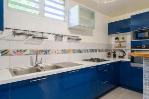 Una cocina con gabinetes azules y un fregadero. en Kayna, en Sainte-Luce 7 fotos más