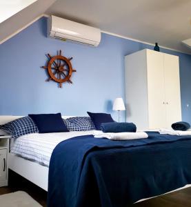 a bedroom with a bed with a blue wall at Lilla Vendégház in Balatonudvari