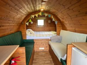 a small room with a bed in a log cabin at Rivendell Glamping Pods in Holsworthy
