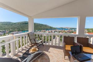 a balcony with a laptop computer on a table at Apartments Nedi in Podglavica