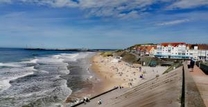 a group of people on a beach near the ocean at Villa Les Pieds dans l'Eau - 4chambres 10personnes - Central & Proche Mer in Le Portel
