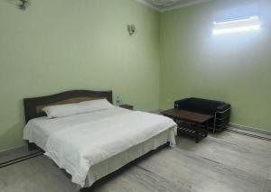 a bedroom with a large bed and a table at Chetiya Farmhouse in Paikbara