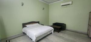 a bedroom with a bed and a chair and a suitcase at Chetiya Farmhouse in Paikbara