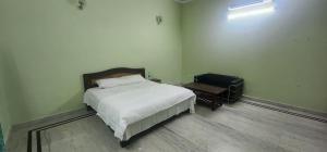 a bedroom with a bed and a table and a suitcase at Chetiya Farmhouse in Paikbara