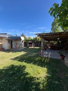 einen Hof mit einer Pergola und einem Haus in der Unterkunft Complejo San isidro in San Rafael