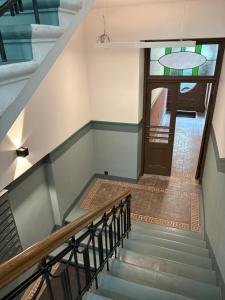 a staircase leading up to a door with a stained glass window at Apartment Matīsa in Rīga +1 photo