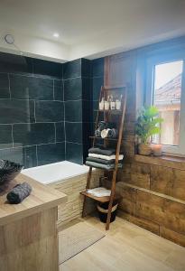 a bathroom with a bath tub and a wooden shelf at L'Ecrin Alsacien - Proche Europa Park - Idéal Famille & Professionnel - Commerces à Proximité in Erstein