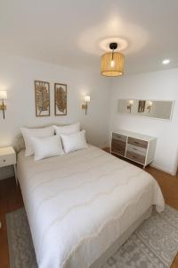 a white bedroom with a large bed and a lamp at L'Ecrin Alsacien - Proche Europa Park - Idéal Famille & Professionnel - Commerces à Proximité in Erstein