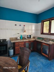 a kitchen with blue walls and a counter with a sink at Casa Ébano Brasileiro in Porto Seguro +2 photos