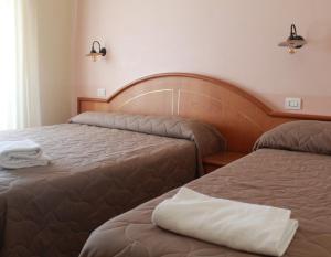 a hotel room with two beds in a room at Hotel Ristorante Benigni in Campagnano di Roma