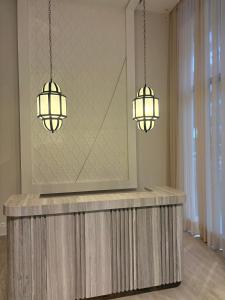 two lights hanging over a counter in a room at Dally Apart Hotel in Rabat