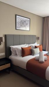 a bedroom with a large bed with orange and white pillows at Dally Apart Hotel in Rabat