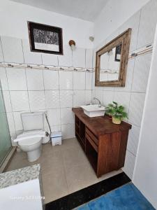 a bathroom with a toilet and a sink and a mirror at Casa Ébano Brasileiro in Porto Seguro