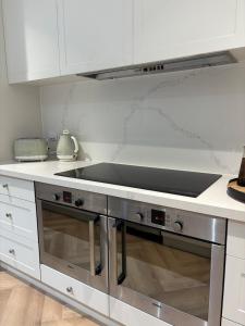 eine Küche mit einem Edelstahlherd oberen Backofen in der Unterkunft Luxury 1-Bedroom Retreat on 10 Acres, near beaches in Chelsea Heights
