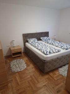 a bedroom with a bed and two rugs at Anes' apartment in Mostar +3 photos