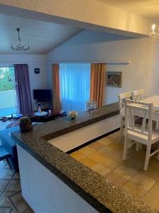 une cuisine et un salon avec une table et des chaises dans l'établissement Duplex Loft Apartment, à Evilard