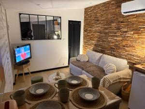 Una sala de estar con un sofá y un televisor. en Chic et confort à deux pas de tout, en Nevers