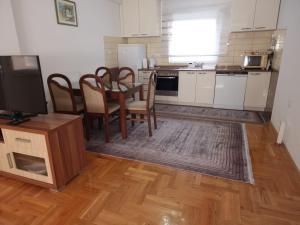 a kitchen with a table and chairs and a television at Anes' apartment in Mostar