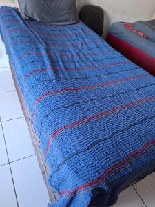 a blue and red blanket on a bed at Casa Próximo da UFPA - COP30 in Belém